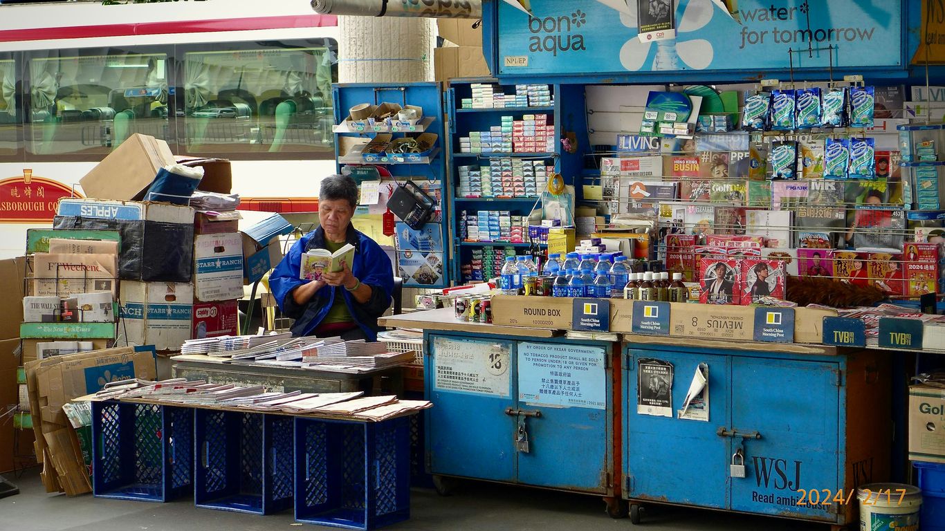 A man standing in front of a store filled with items