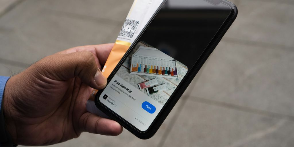a person holding an iphone with a credit card in their hand