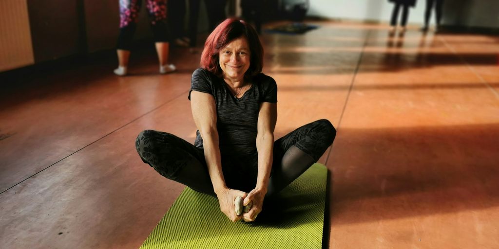 woman in black tank top and black pants lying on green mat
