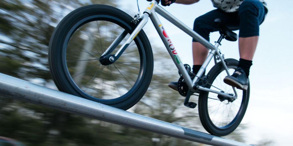Cyclist performing a peg grind on a BMX bike.