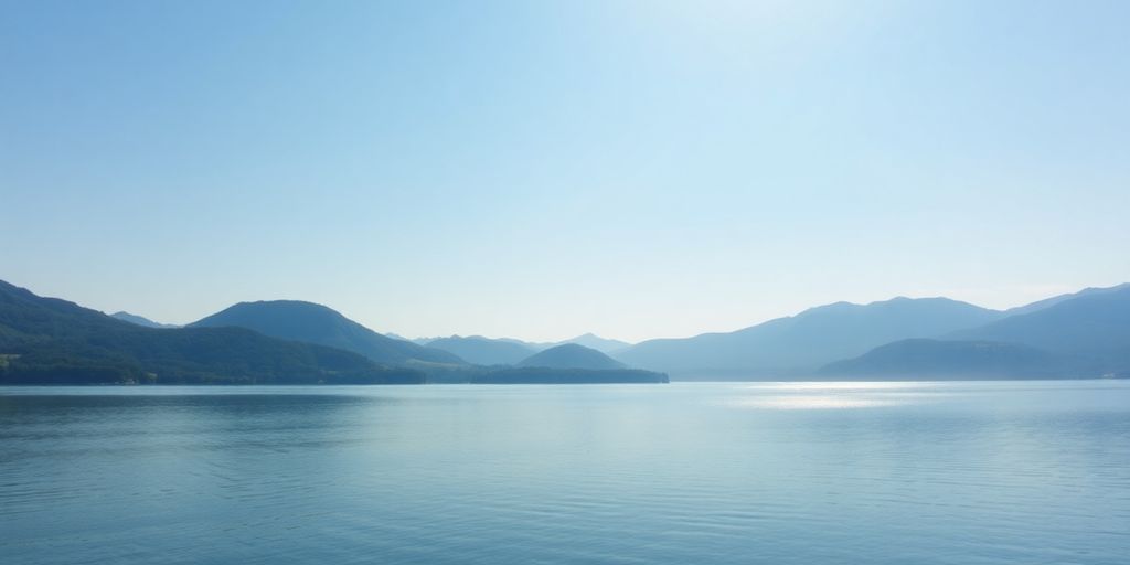 Paysage paisible avec un lac et des collines verdoyantes.