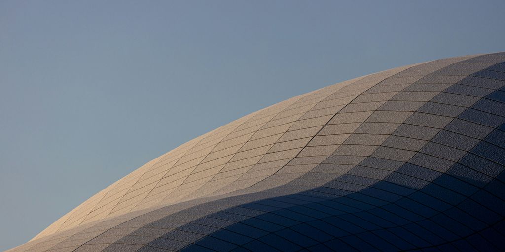 a large building with a plane flying in the sky