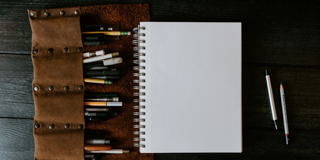 white spiral notebook on brown wooden table