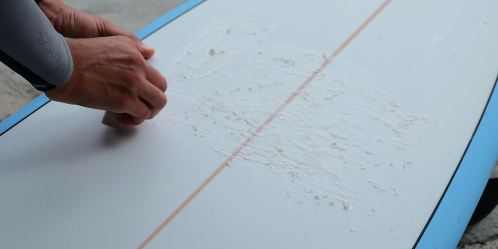 a person is holding a surfboard with writing on it