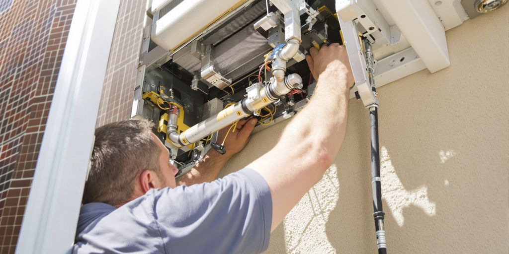 Technician installing an HVAC unit on a sunny day.