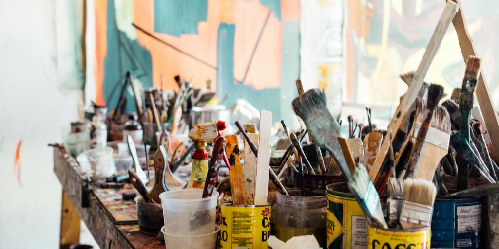 assorted-color paint brush on brown wooden table top