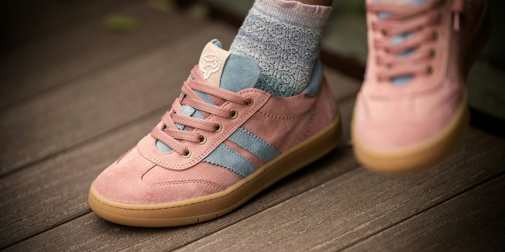 Pink sneakers with blue stripes are on display.
