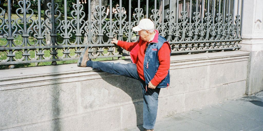 woman in blue jacket and blue denim jeans standing on gray concrete floor during daytime