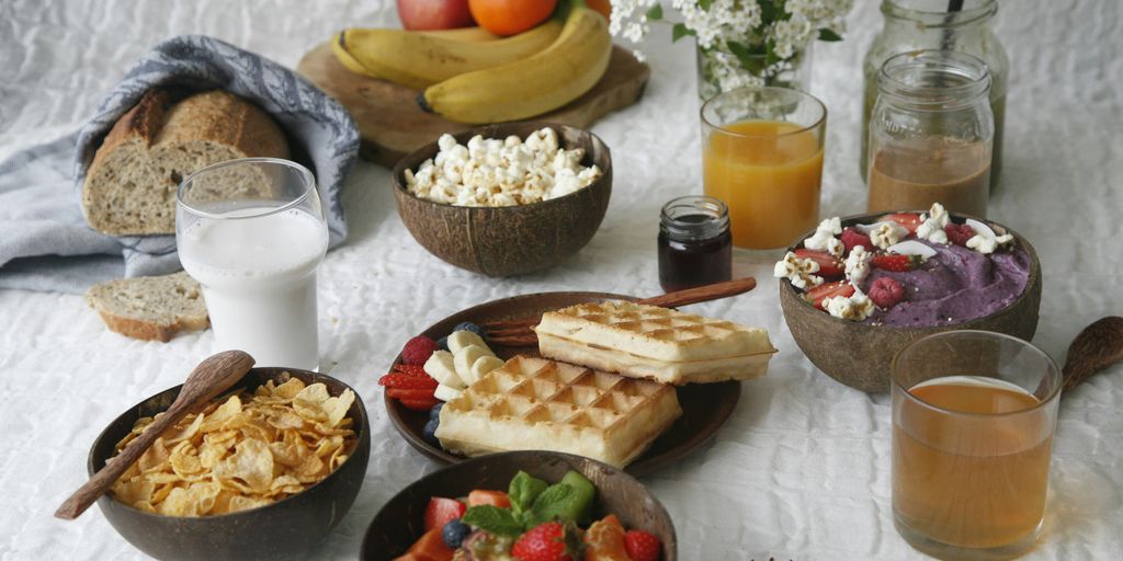 sliced bread with sliced tomato and green leaf vegetable on white ceramic plate