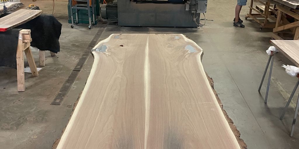 A large wooden slab being prepared in a workshop.