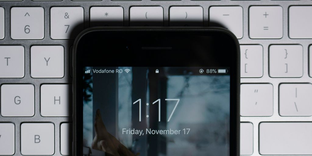 black iPhone on gray computer keyboard