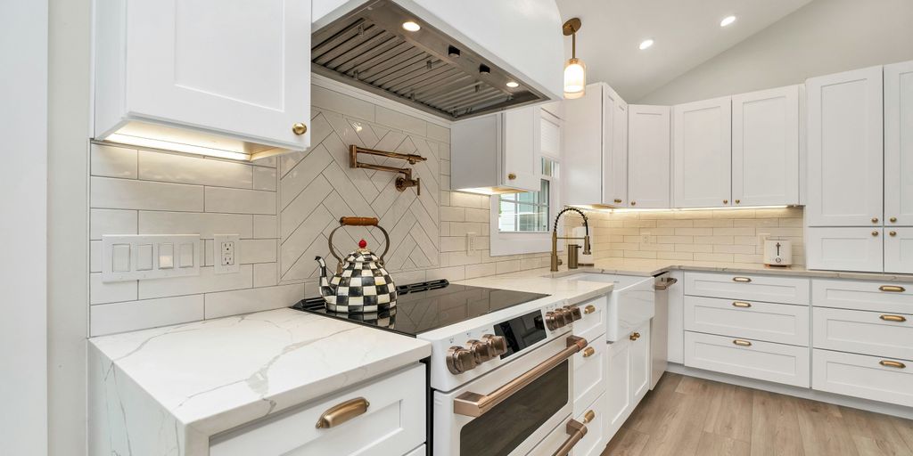 a kitchen with white cabinets and a stove top oven
