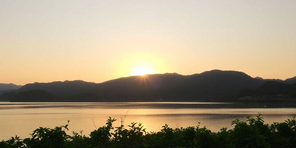 Serene sunset over tranquil waters and lush greenery.
