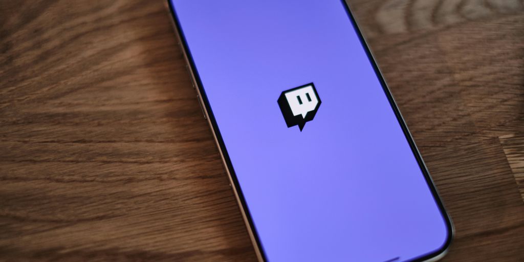 A cell phone with a purple background and a black sticker on the back of