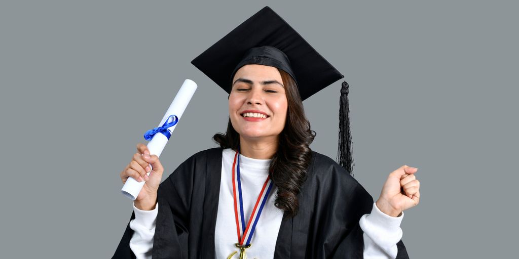 a man wearing a graduation cap and gown holding a diploma