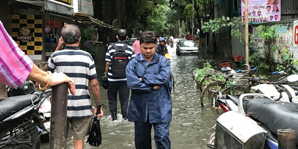 people walking on flooded streets during day