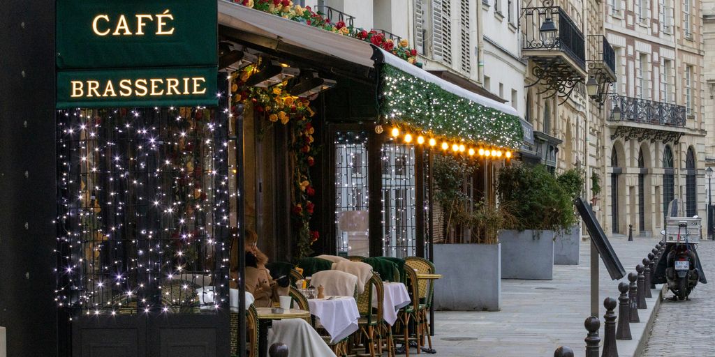 a cafe with lights on the outside of it