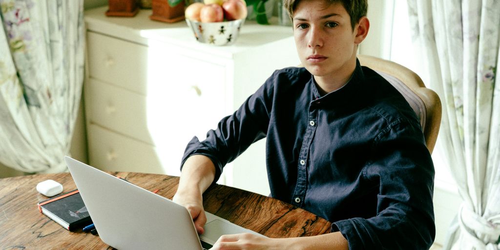 a man sitting at a table using a laptop computer