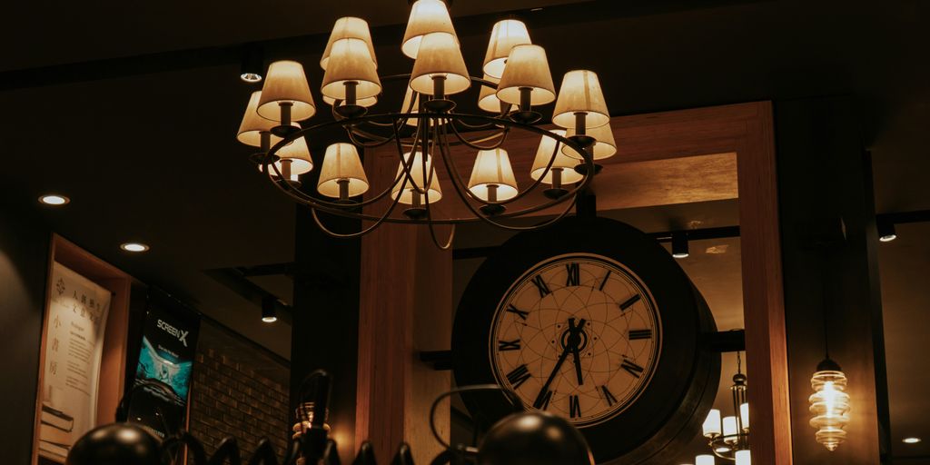 Elegant chandelier hangs above a vintage clock.
