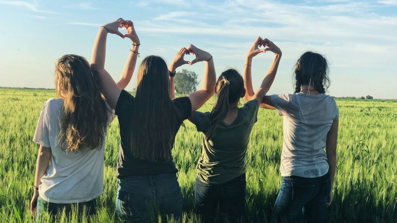 women forming heart gestures during daytime