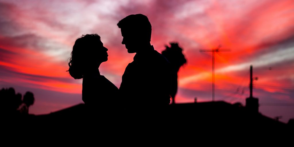 silhouette of man and woman facing each other during golden hour
