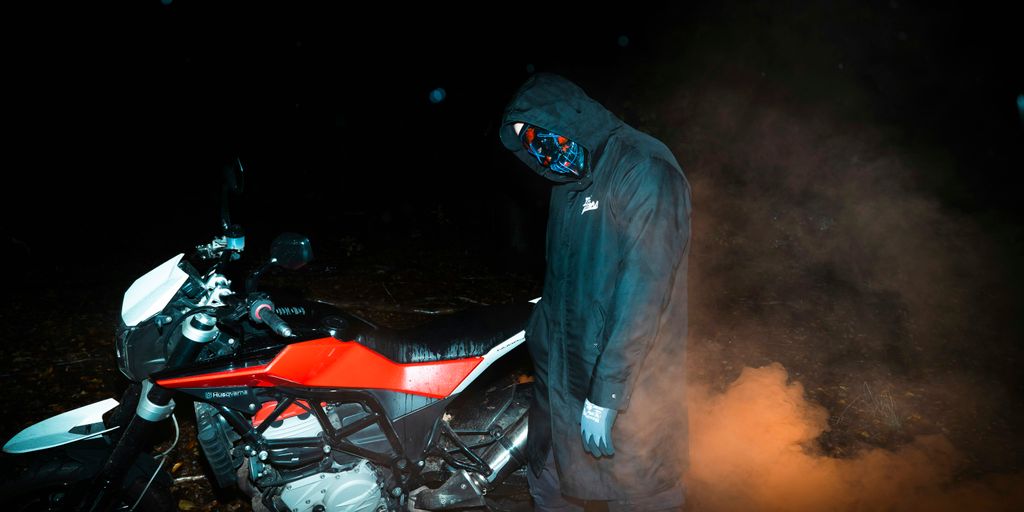 a man standing next to a motorcycle in the dark