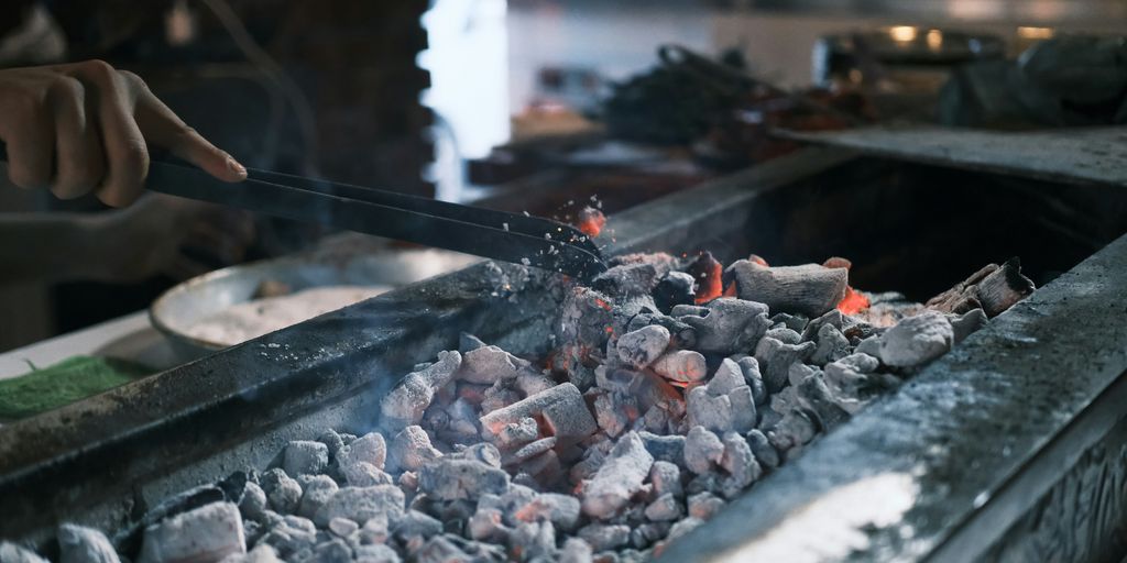 A person cooking food on a grill in a kitchen