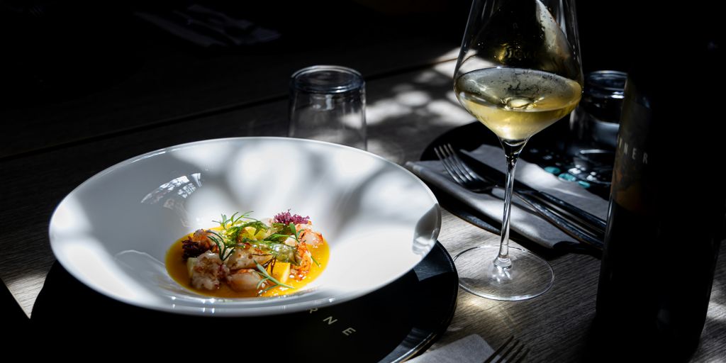 A beautiful meal is served with a glass of wine.
