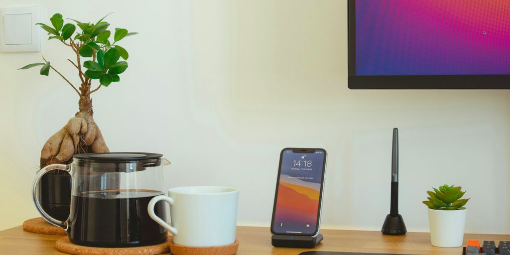 black iphone 7 beside white ceramic mug on brown wooden table