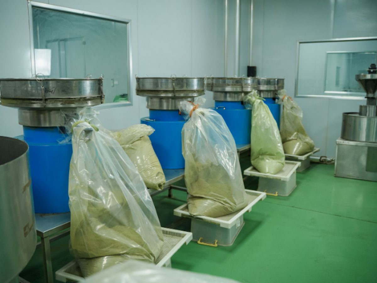 Industrial setting with machinery and bags of powdered substance.