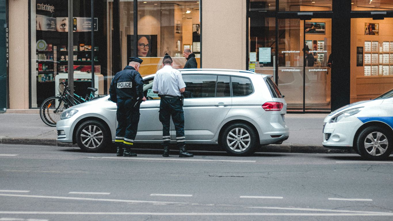 two police officers standing on the back of a car