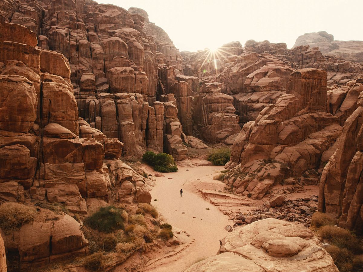 a person walking through a canyon in the desert