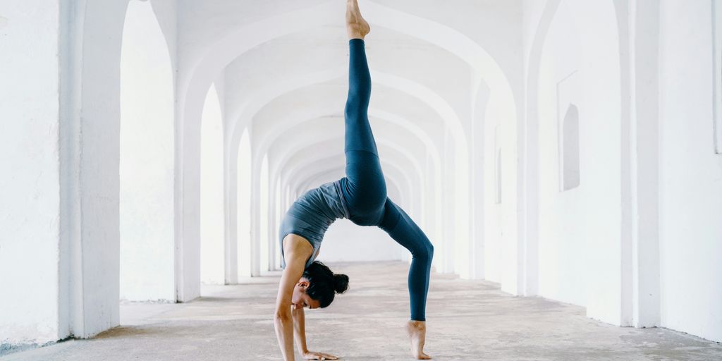 woman in blue leggings and black tank top doing yoga