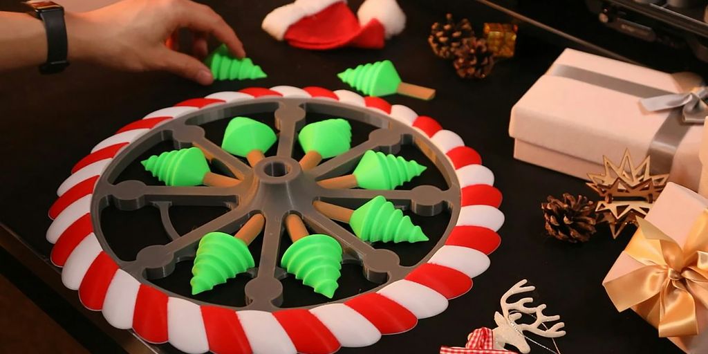 A person decorating a christmas cake with green and red icing