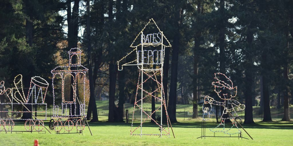 a group of sculptures in a park with trees in the background
