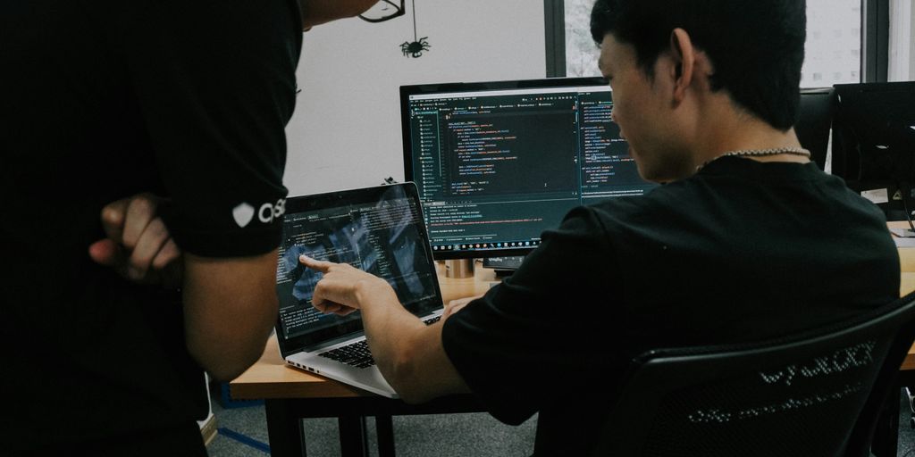 two men working on computers in an office