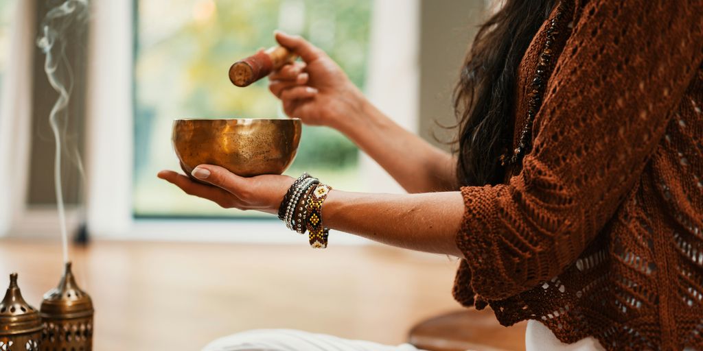 woman in brown knit sweater holding brown ceramic cup