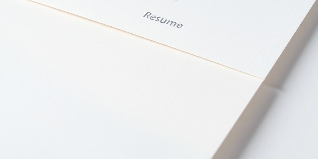 Textured resume paper stack with subtle watermarks.