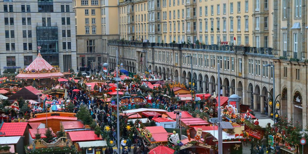a crowd of people standing around a christmas market