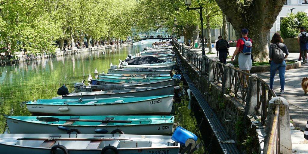Boats line a canal next to a walkway.