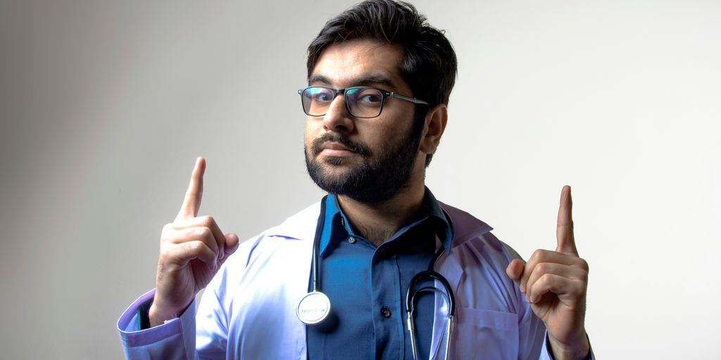 man in blue scrub shirt wearing black framed eyeglasses