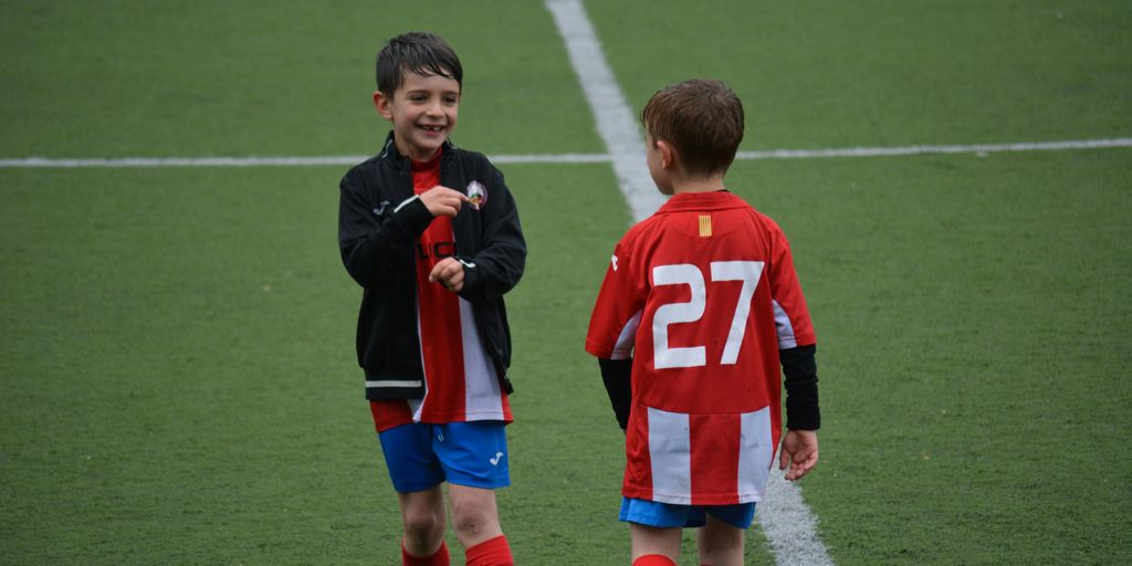 two boy standing on soccer field