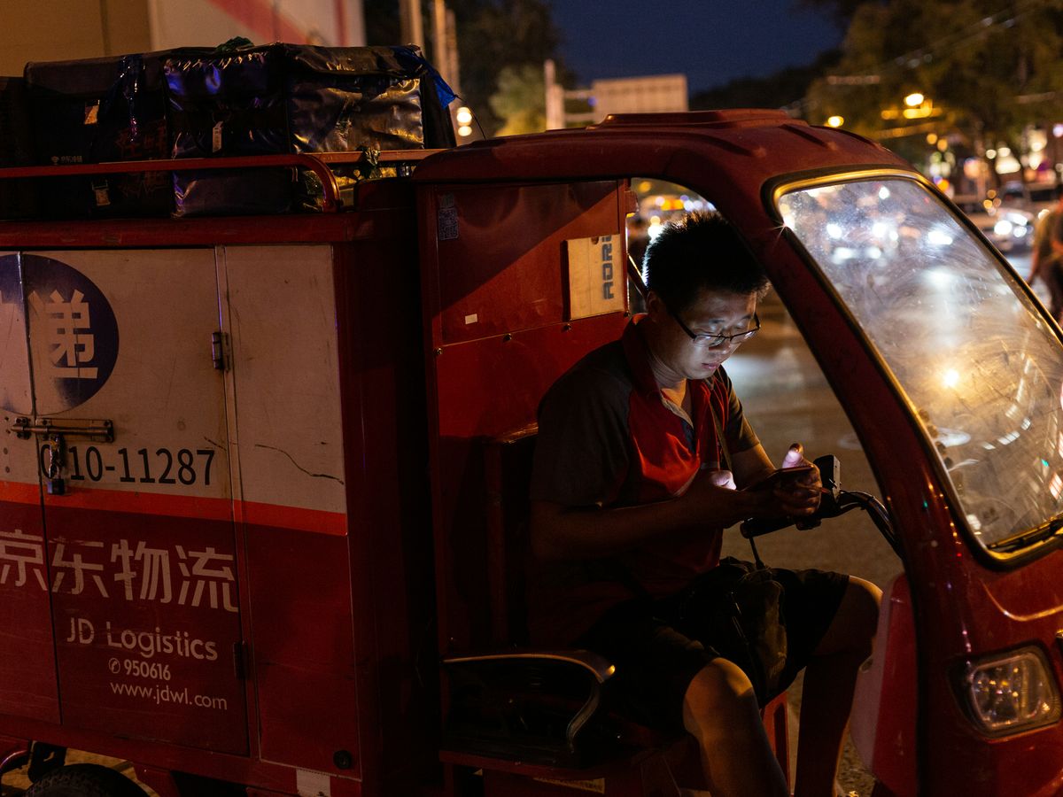 man in red polo shirt sitting on red car