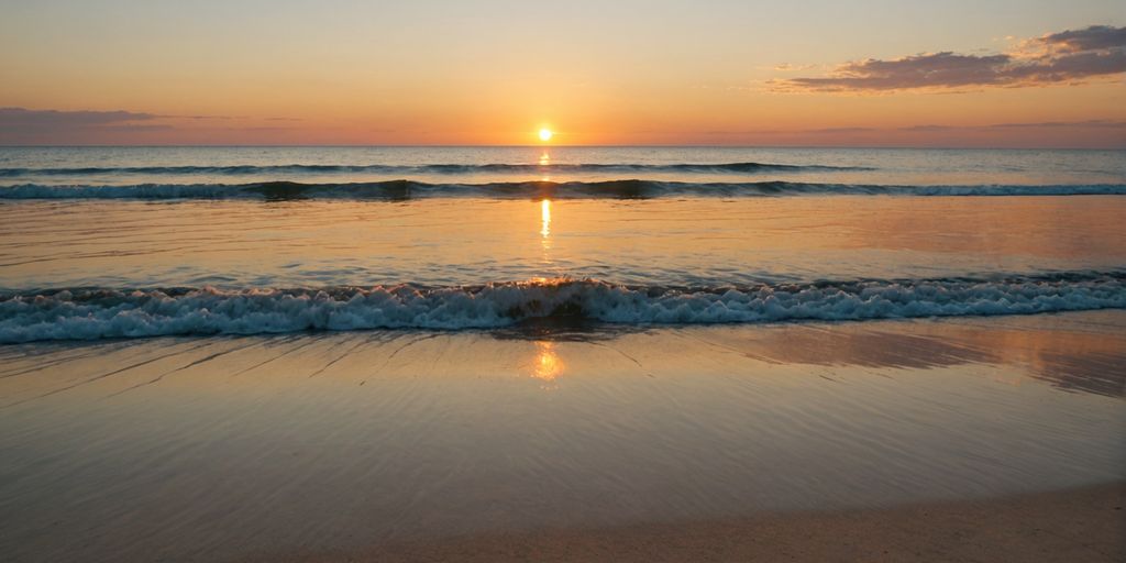 Sunrise over a calm beach with gentle waves.