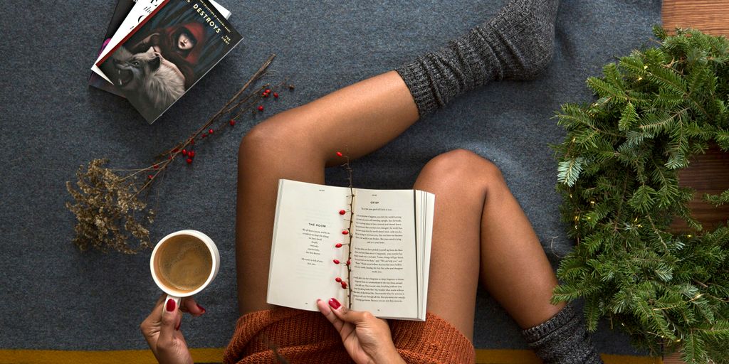 opened book on person's lap with gray socks