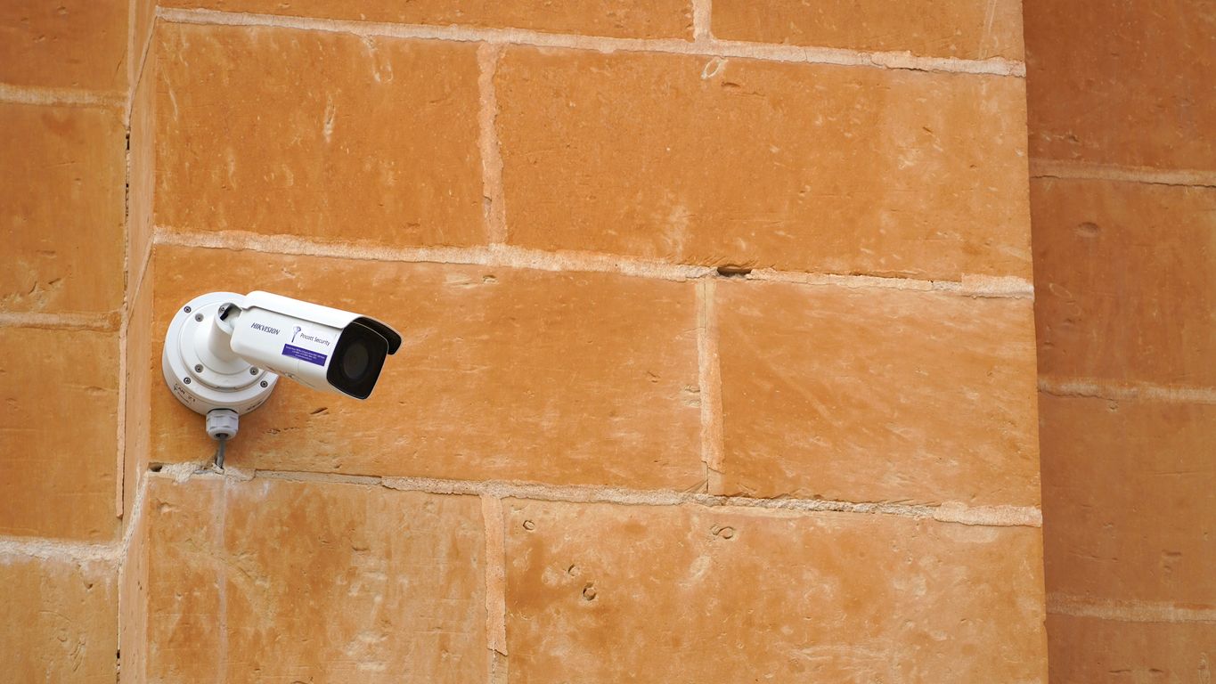 A security camera attached to a brick wall