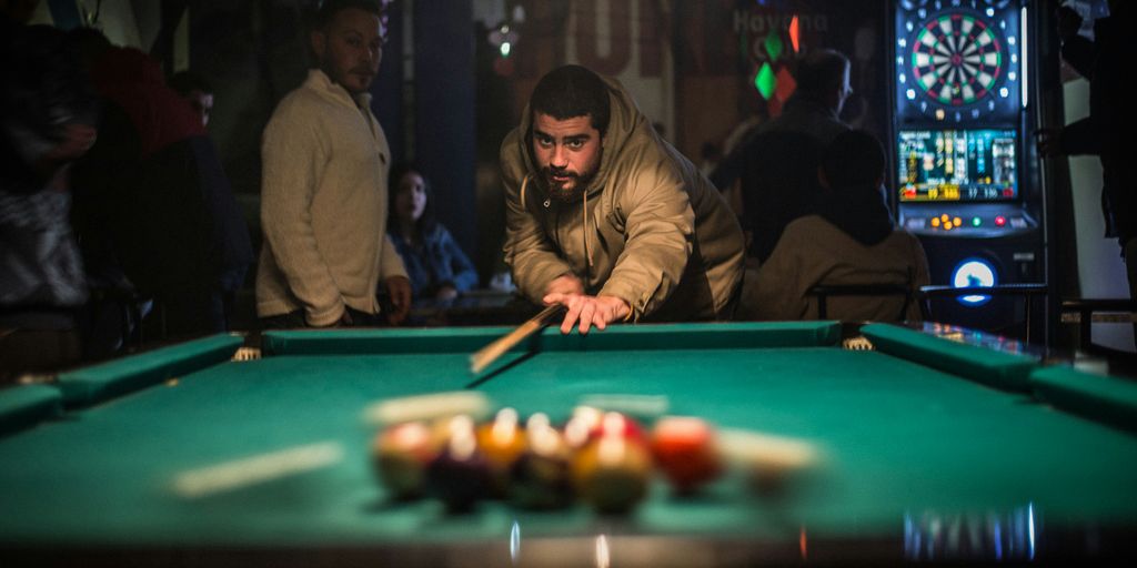 man in brown jacket playing billiard