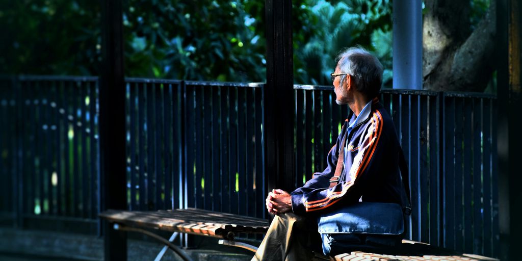 man sitting on wooden bench