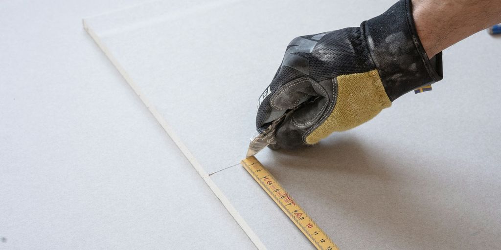 a person measuring a piece of paper with a tape