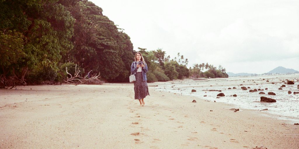 a woman standing on a beach next to the ocean